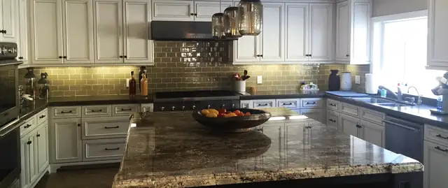 Bloomfield, MI kitchen with white raised-panel cabinets, granite island, glass mosaic backsplash and pendant lights